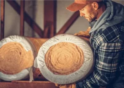 Un couvreur portant des rouleaux de laine de verre