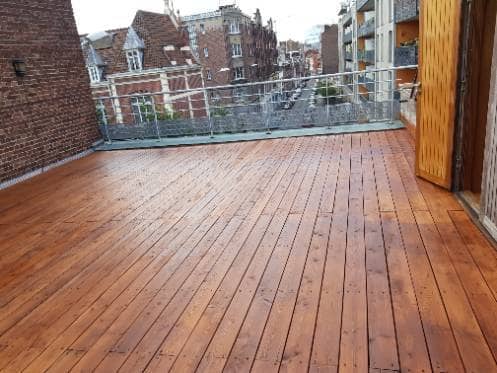 Terrasse en lames de bois terminée sur un toit plat, avec son garde-corps