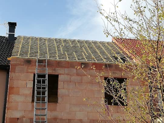 Maison neuve en brique, toiture liteaunée sur écran de sous-toiture avant la pose des tuiles