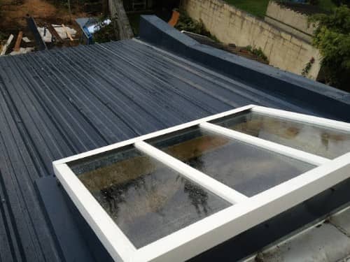 Verrière à trois vantaux posée sur une couverture en bac acier gris anthracite