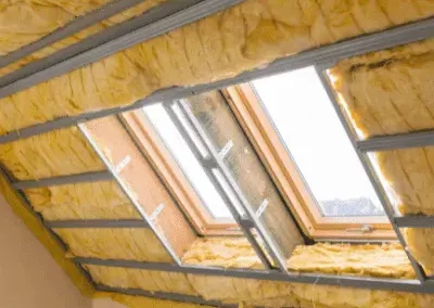 Des combles isolés avec de la laine de verre posée sur rails